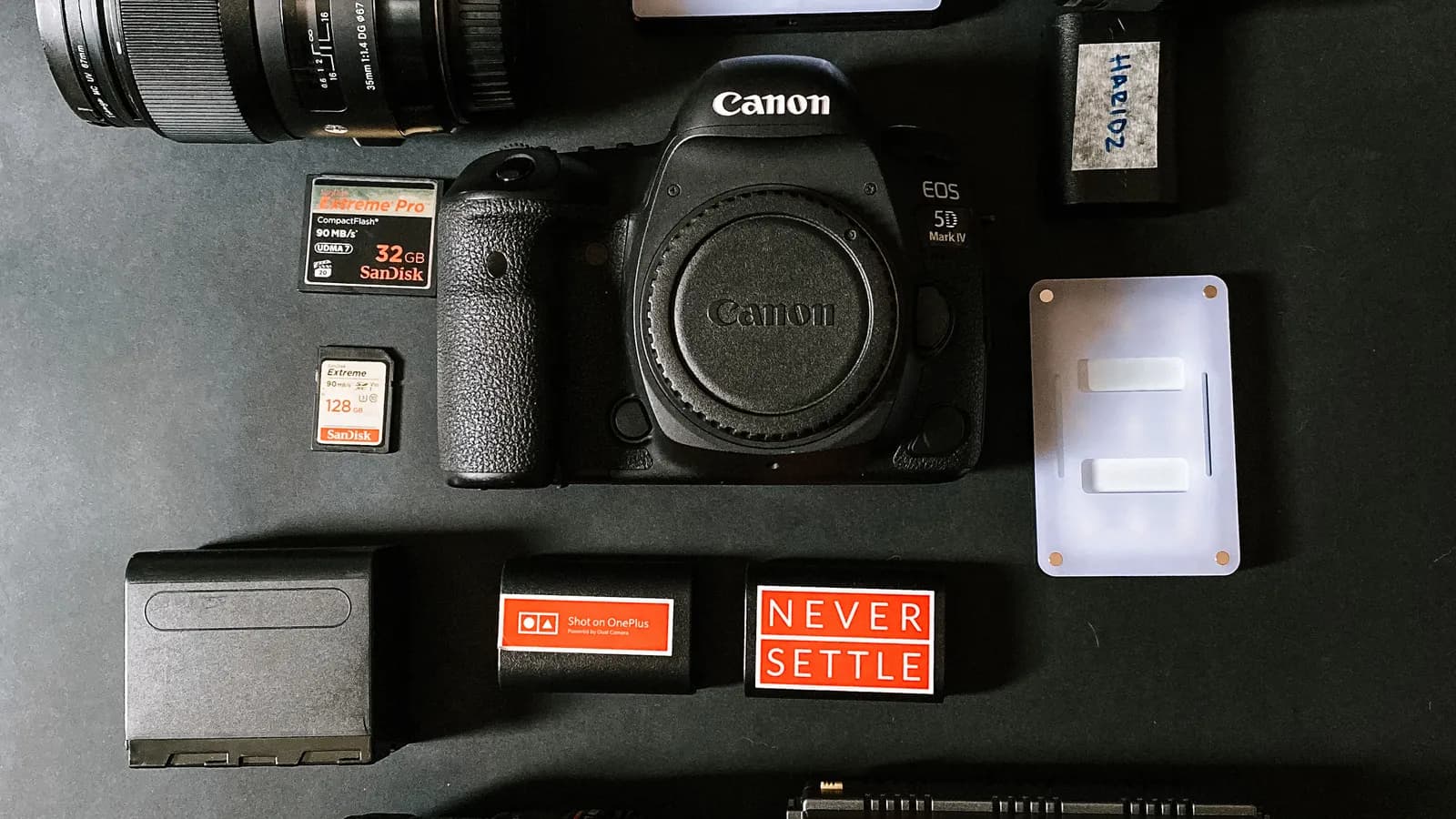 Camera, lenses and accessories organised on a dark surface